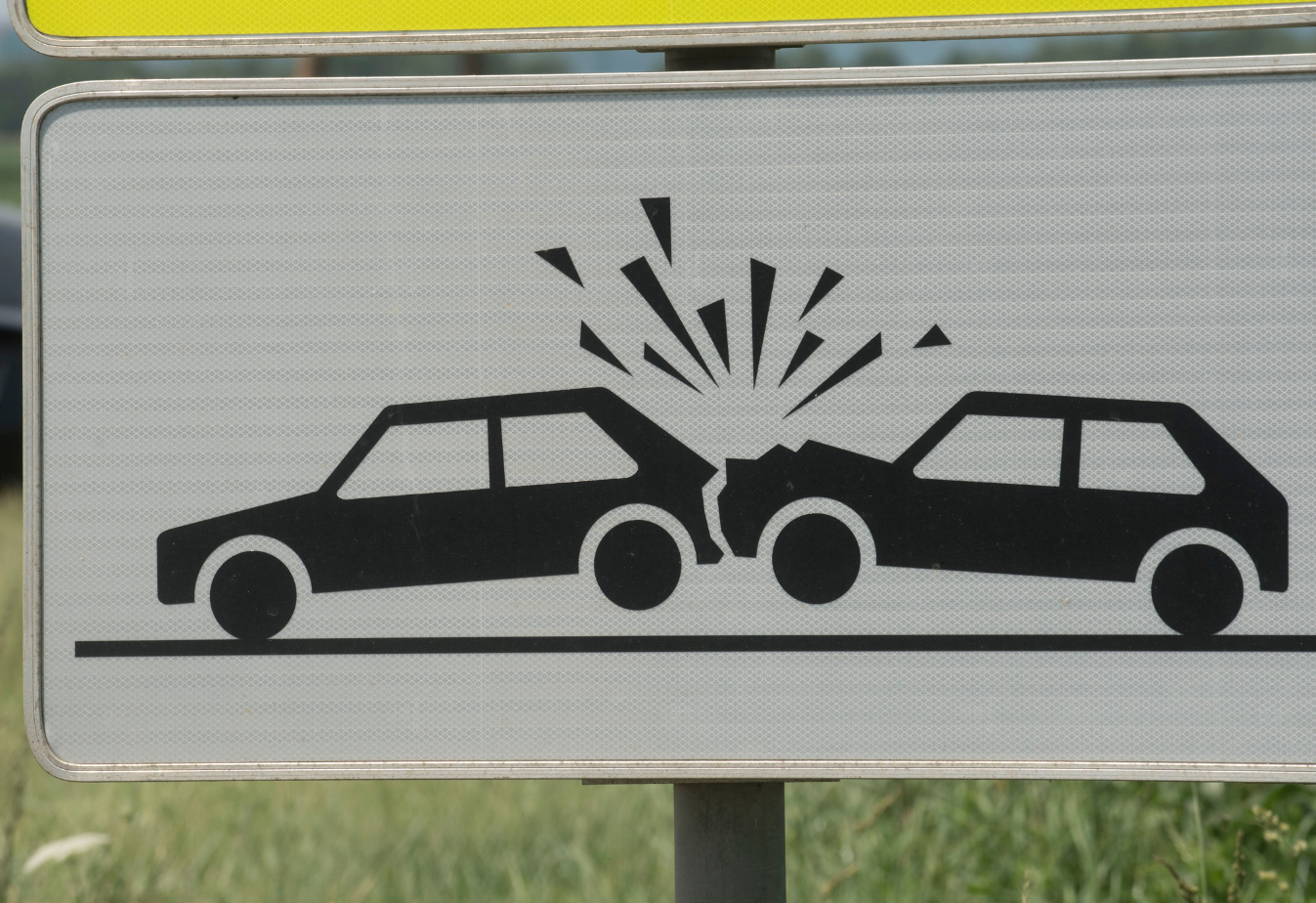 road sign with drawing of a car hitting the back of another car