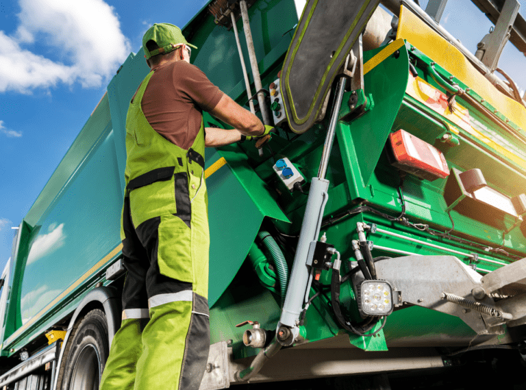 man standing on garbage truck