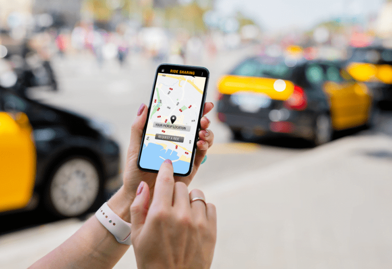 someone holding a smartphone with a rideshare app open ordering a ride to their location