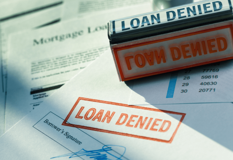 mortgage application paper with a red stamp that reads loan denied