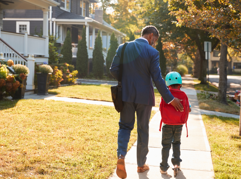 father and son walking on a sidewalk