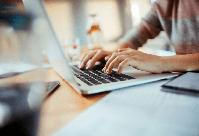 close up shot of a person's hands on a laptop keyboard