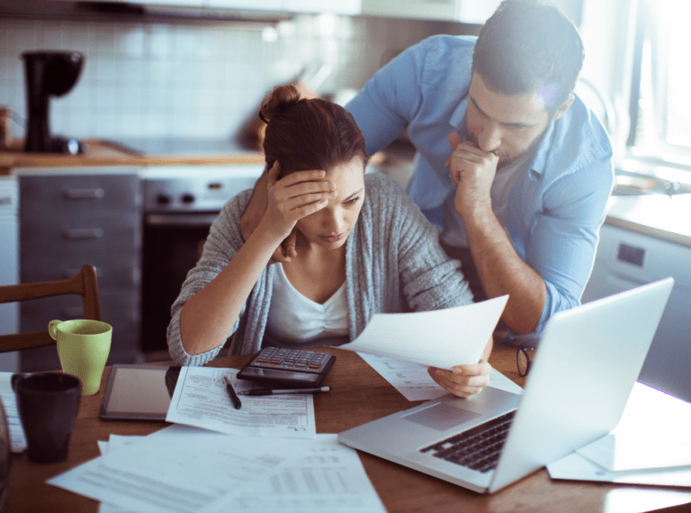 two people sitting reviewing bills in a kitchen