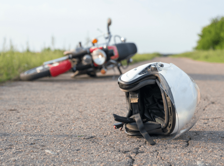 downed motorcycle in the background, white helmet in the foreground