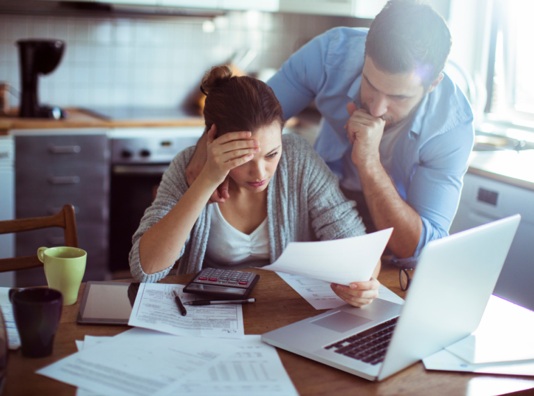 two people viewing bills and a computer