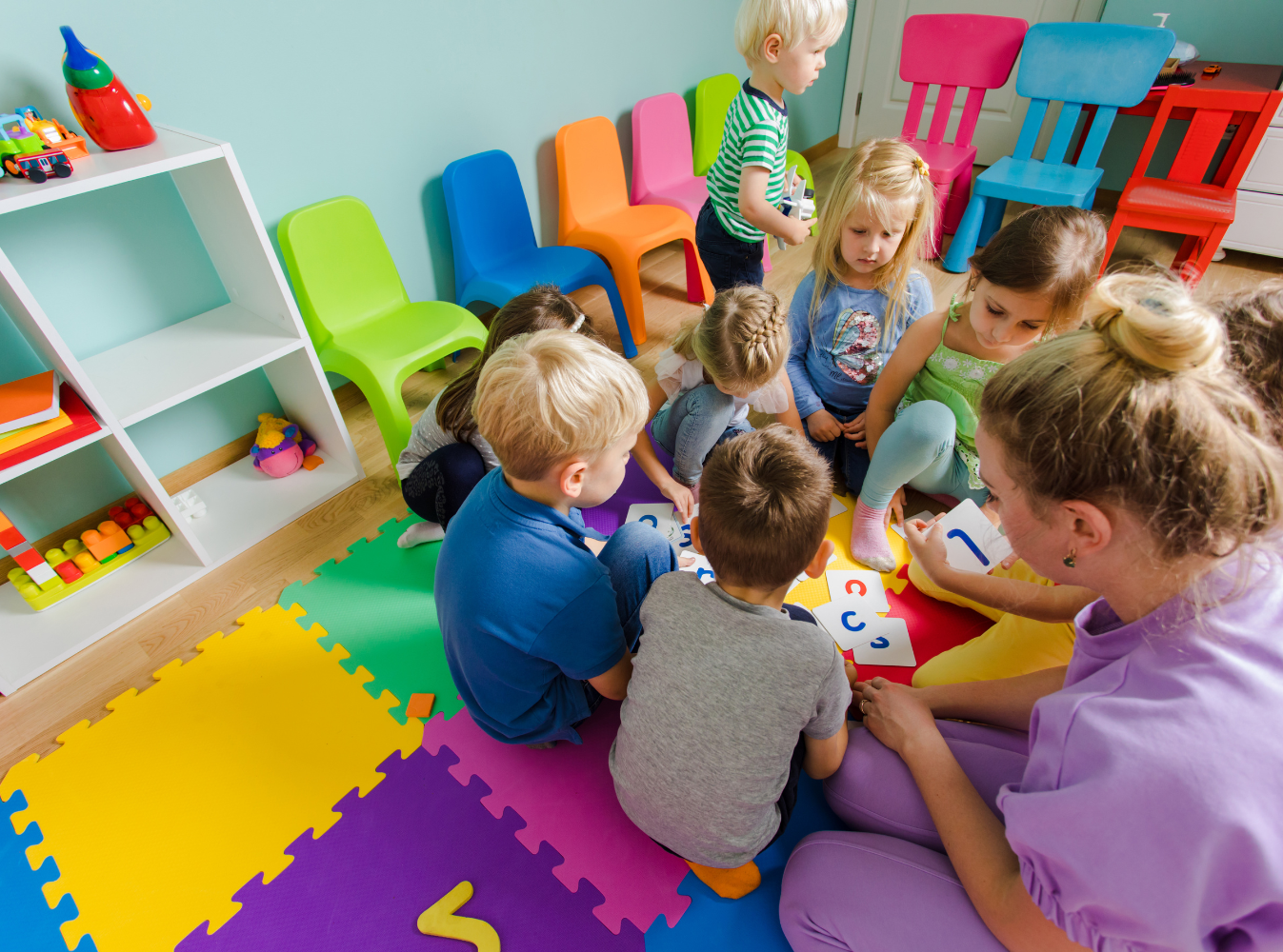 a group of kids at daycare with a teacher